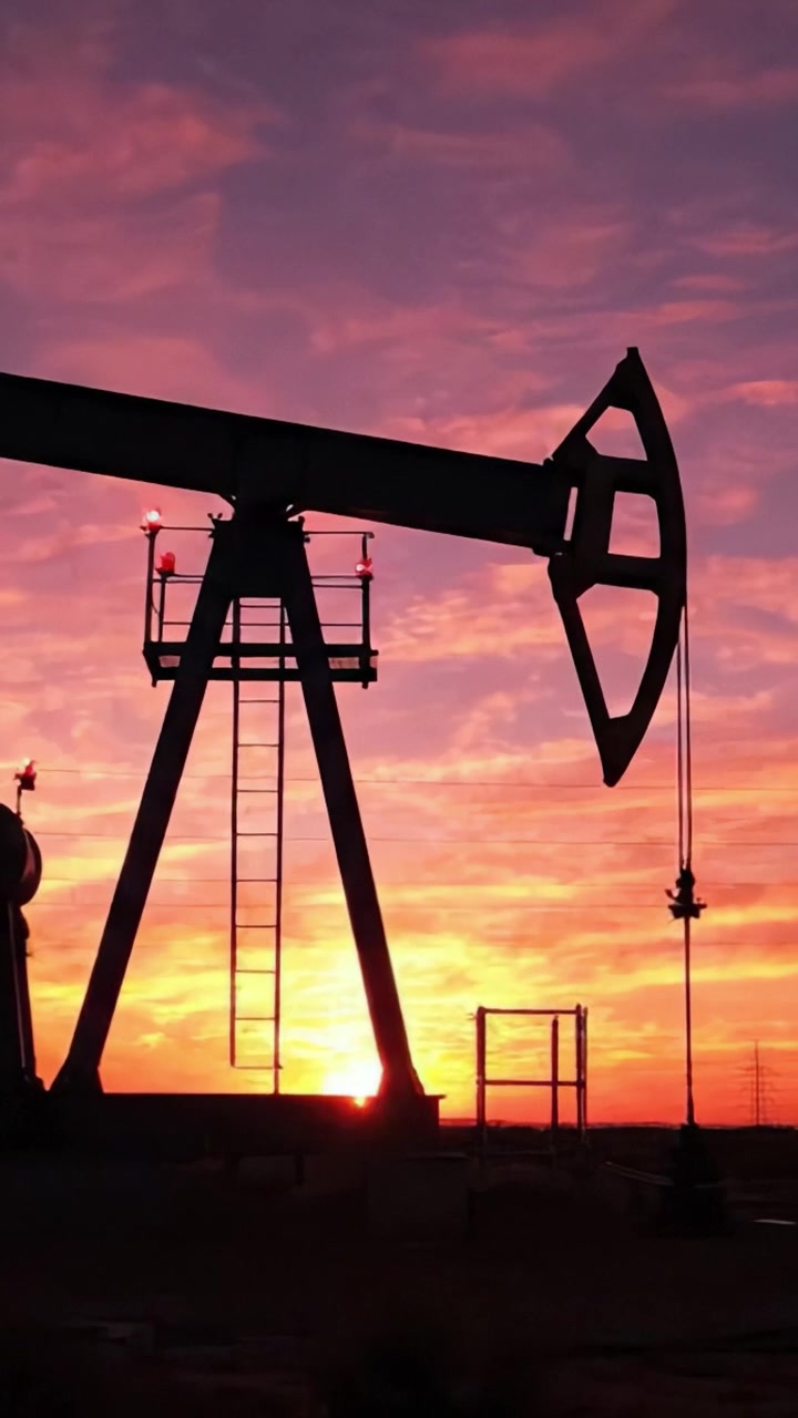 Silhouette of an Oil Pump Jack Against a Vibrant Sunset Sky, Capturing the Essence of Energy Production and Natural Beauty in One Frame