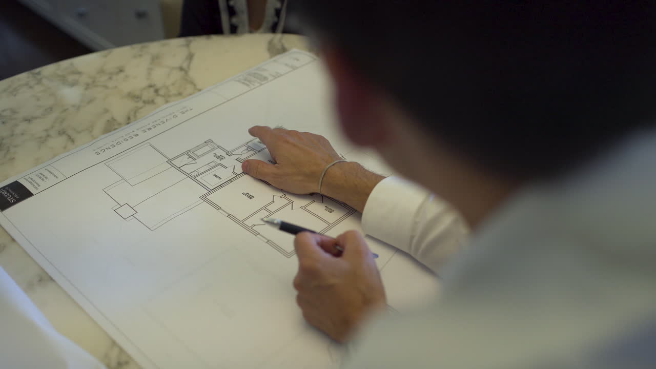 arquitecto repasando planos con clientes.