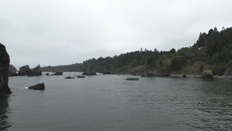 Rocky-coast-of-Trinidad-bay-in-low-aerial-flyover,-Oregon,-USA