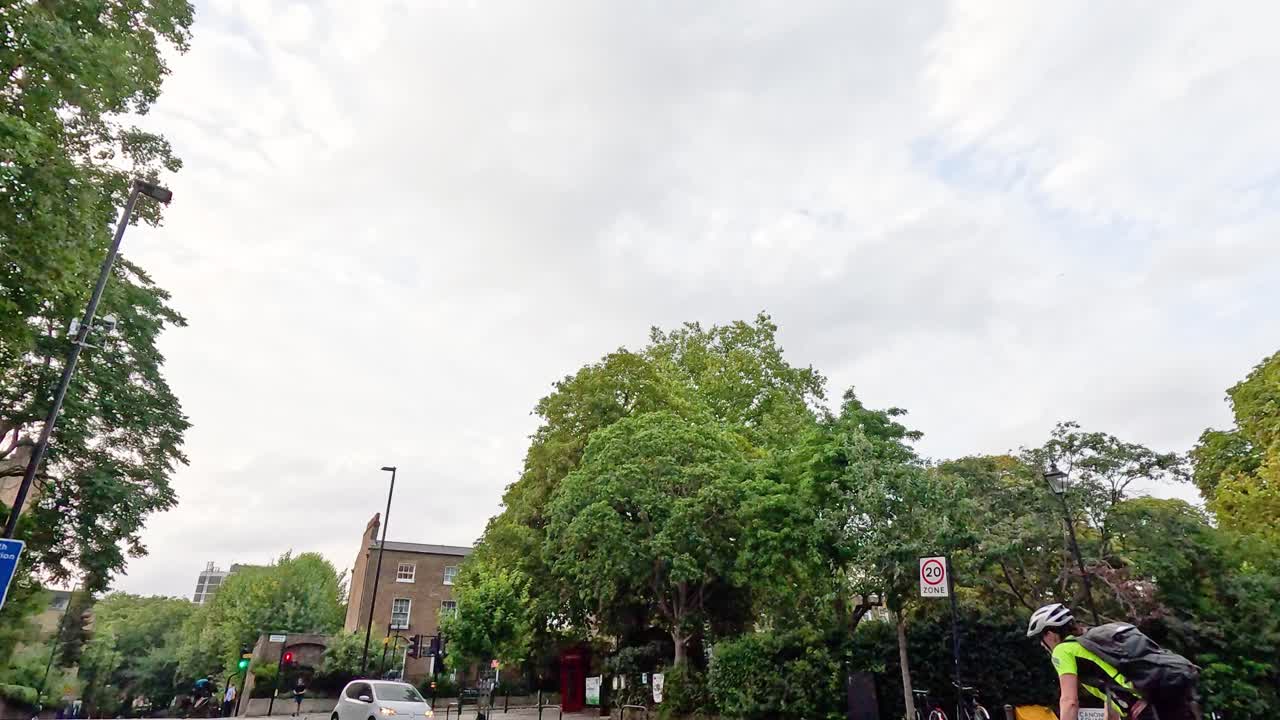 런던 거리에서 자전거와 자동차가 움직이고 있습니다.