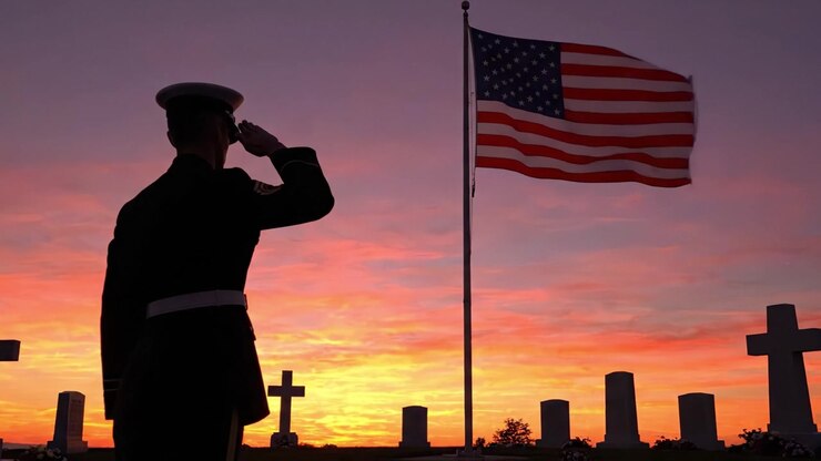 Un Solenne Tributo Militare al Crepuscolo: Un Membro del Servizio Saluta la Bandiera Americana Mentre si Trova Tra le Lapidi al Tramonto in un Cimitero