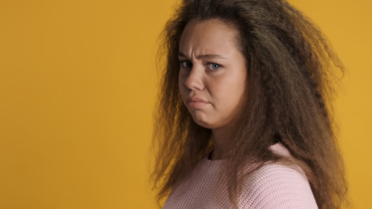 Upset Caucasian curly haired woman in front of the camera.