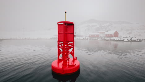 red metal buoy floating in cold norwegian sea