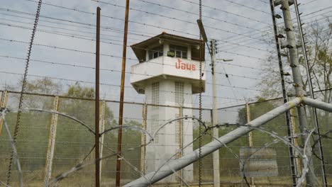 prison watch tower with barbed wire and razor wire fence inside jail prison, high security prison