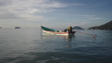 a person on a traditional longtail boat in calm tropical waters