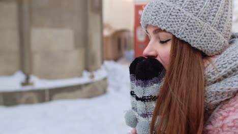 Close-up-of-young-tourist-woman-warming-her-cold-hands-outdoors-in-winter-day-on-street-in-city