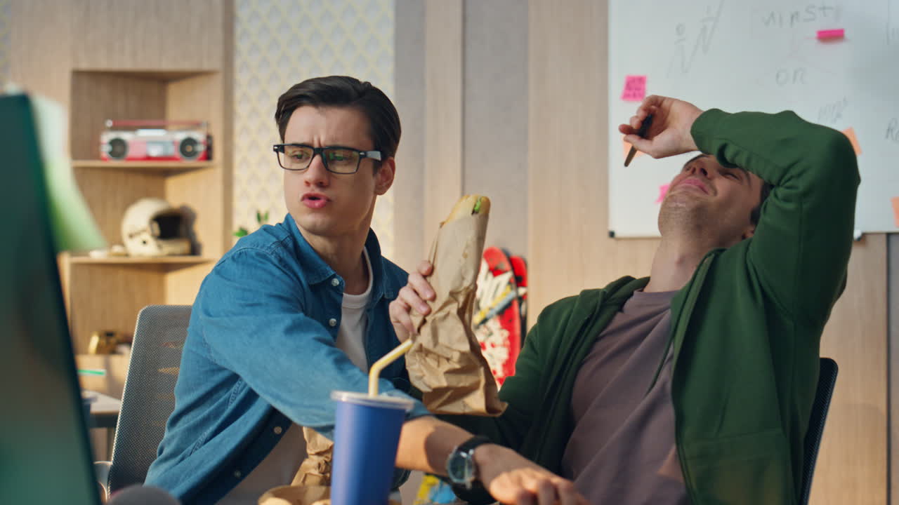 흥분한 팀 동료들이 점심을 먹고 컴퓨터 사무실을 가게 보고 있습니다. 웃는 친구들