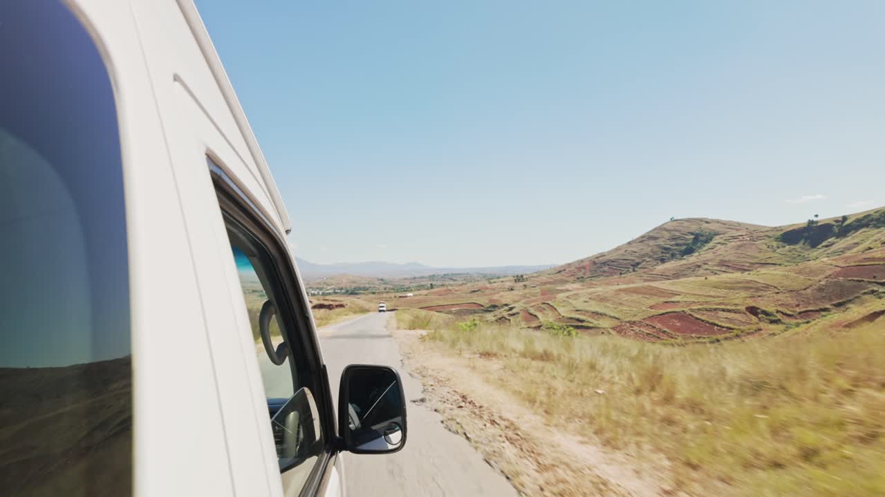 La vista desde el autobús del hermoso paisaje con colinas y bosque en un día soleado.