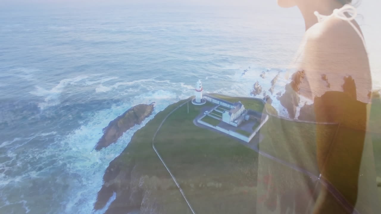 Gazing over ocean view, person standing near lighthouse on coastal cliff