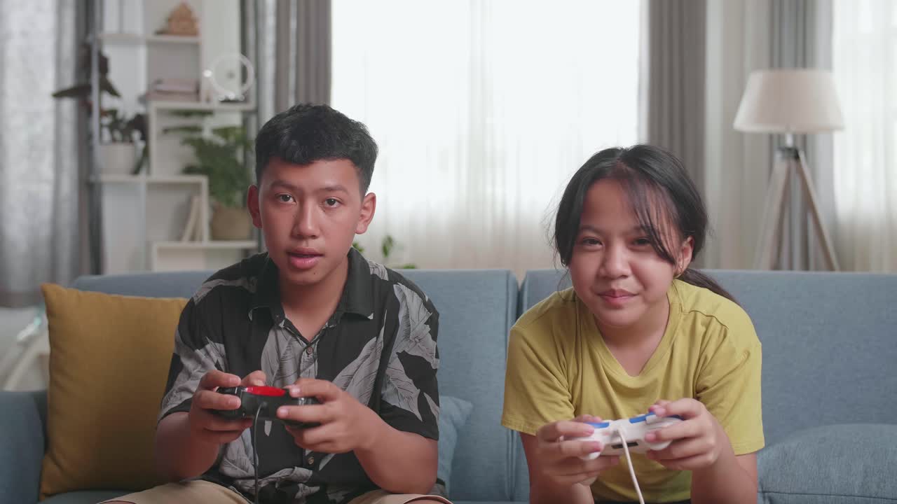วัยรุ่นกำลังเล่นวิดีโอเกมที่บ้าน