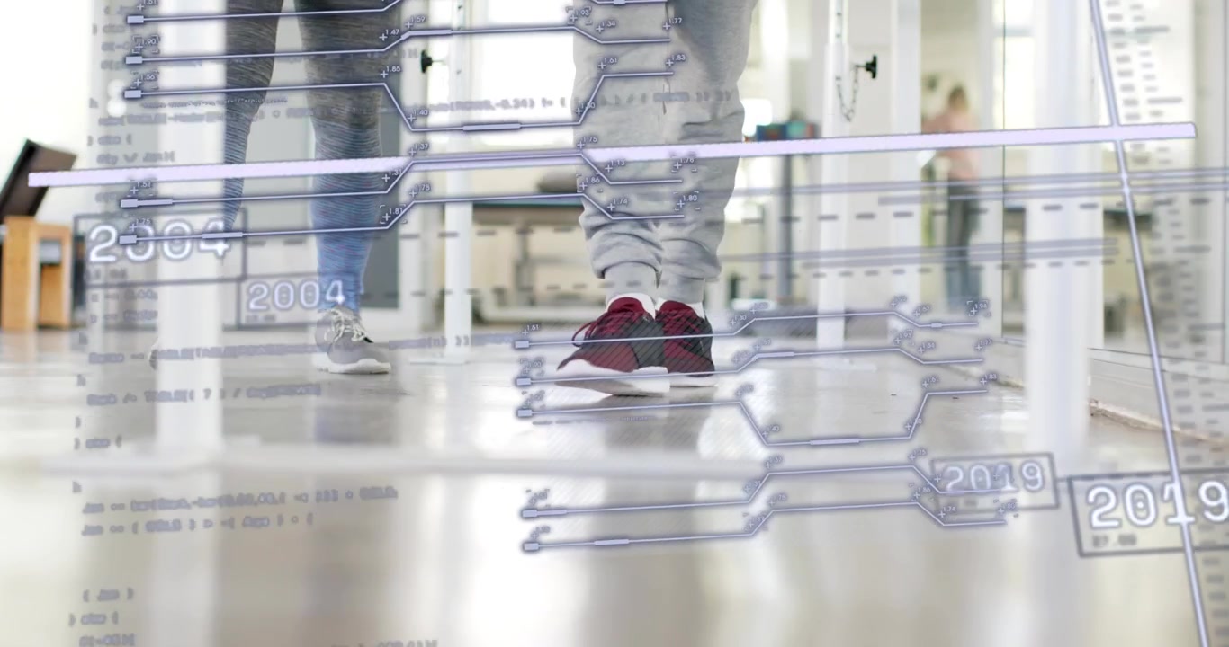 Al secondo segno, colleghi che camminano sul pavimento di un laboratorio di analisi del passo con una sovrapposizione di timeline che appare, mostrando una serie di anni.