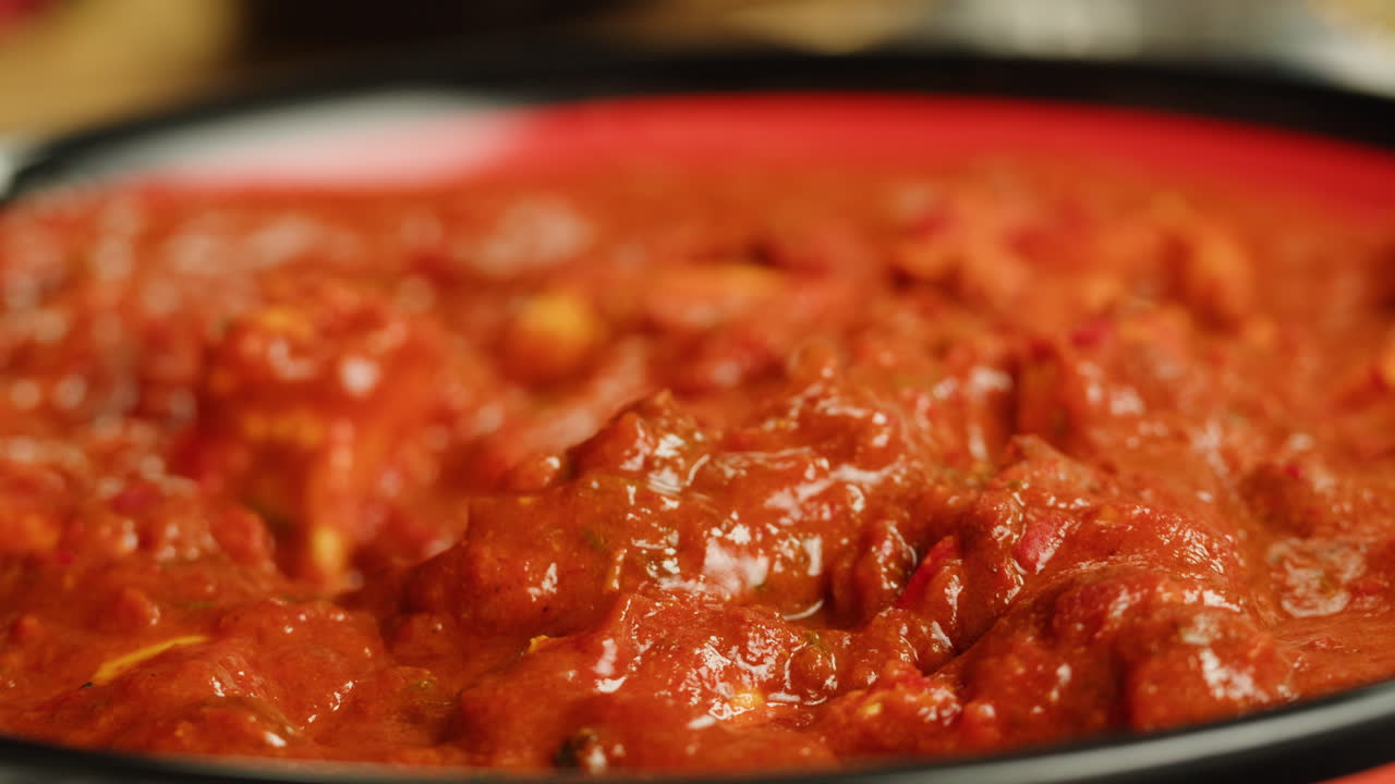 Assorted indian sri-lanka food set on wooden background. Dishes and appetisers of indeed cuisine, rice, lentils, paneer, samosa, spices, masala. Bowls and plates with indian food top view chicken. High quality 4k footage