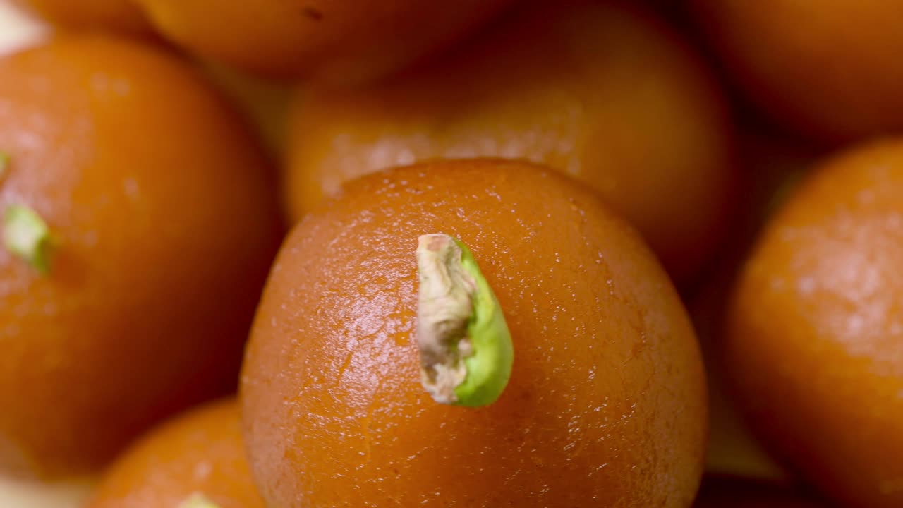 gulab jamun girando con pistacho encima ( dulce indio ) | postre | tiro de primer plano extremo