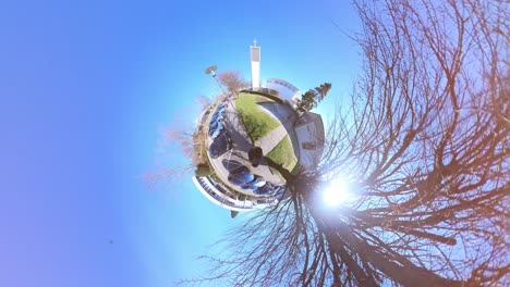 little tiny planet 360 small world view of a man walking past trees and cars towards a church in 4k