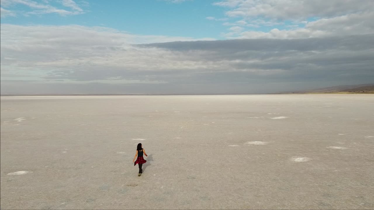 Flying over a girl walking on the pink salt lake, the largest dry lake in Turkey and one of the largest salt lakes the world