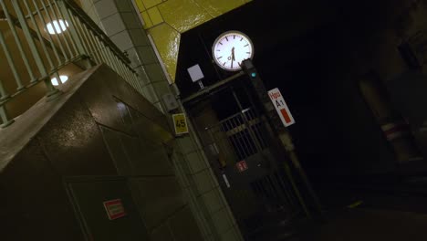 Handgehaltener-Surrealer-Dolly-Rückwärts-Rotierender-Schuss-Einer-Uhr-In-Einer-U-bahnstation-Mit-Reifenwänden,-Gruselig-Und-Verwirrend