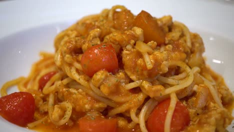 dolly orbit shot de delicioso espagueti italiano servido con tomate en la parte superior