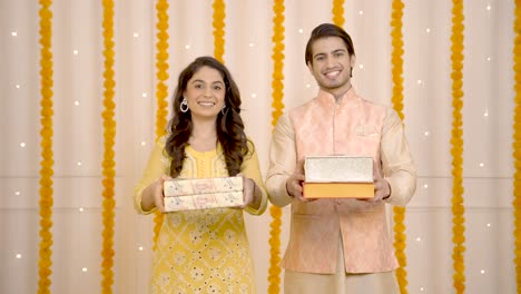 pareja india ofreciendo regalos en diwali