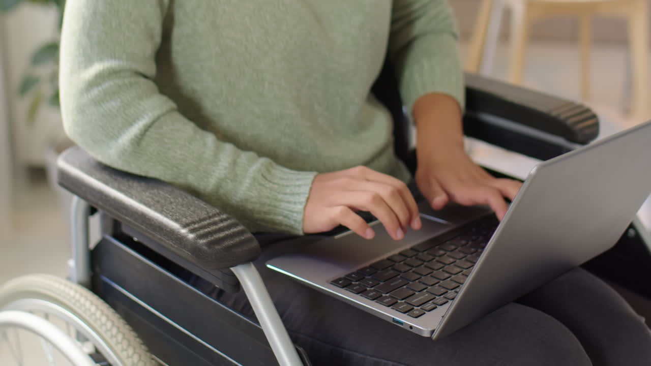 Woman using a laptop in a wheelchair