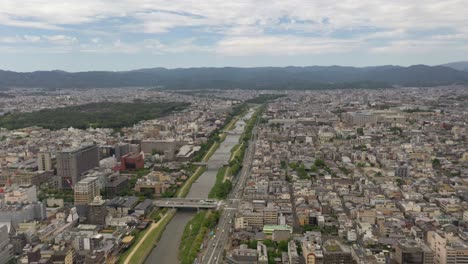 Amazing-aerial-of-Kyoto-with-Kamo-river,-temples,-mountains,-and-city-skyline-in-Kyoto,-Japan