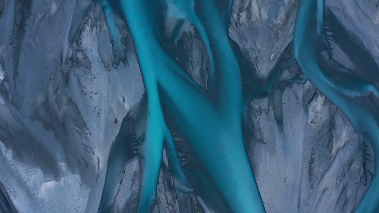 Top down aerial shot of Blue Glacial Braided River delta that looks like abstract art, Godley River, New Zealand