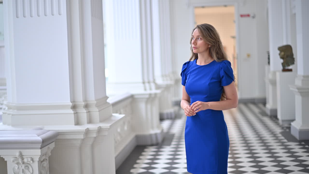 Brunette woman in blue dress moving through the National Museum of Fine Arts in Chisinau, Moldova