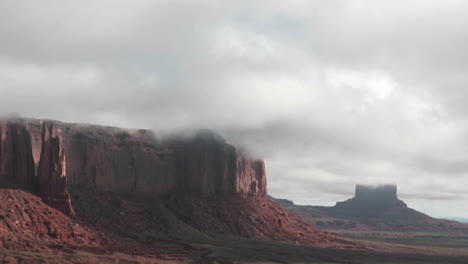 clouds stream over rock formations in monument valley utah