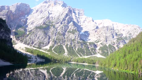 reflejo épico de las dolomitas en el agua boscosa del lago di braies, italia