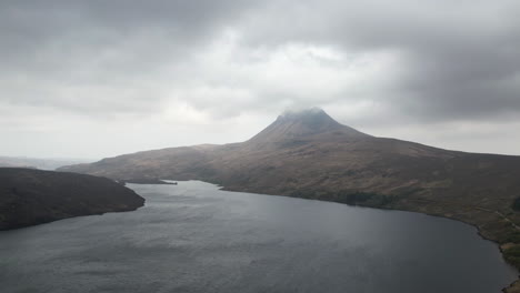 Hyperlapse of moving clouds over the mountain&rsquo;s peak and the lake in Scottish Highlands
