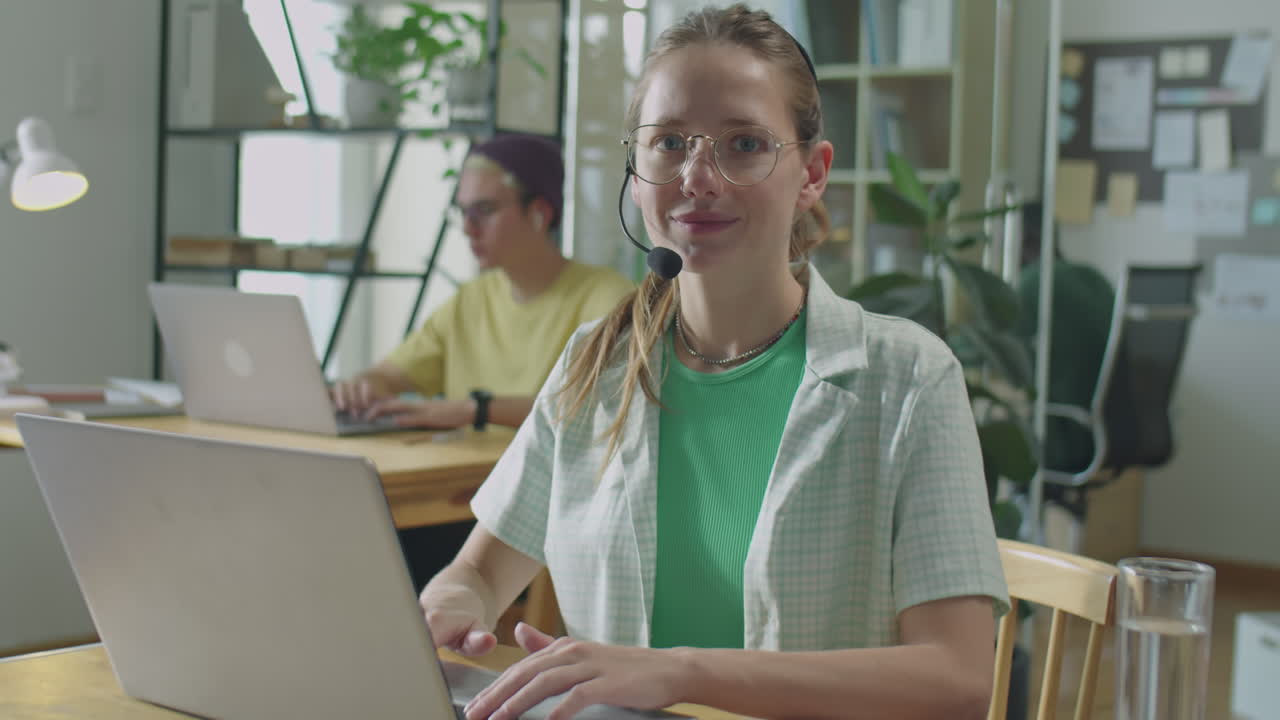 Portrait of Girl in Headset Working on Laptop in Office