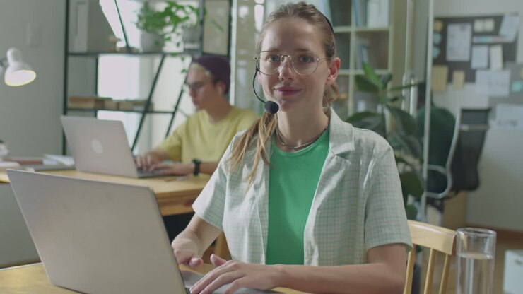 Portrait of Girl in Headset Working on Laptop in Office