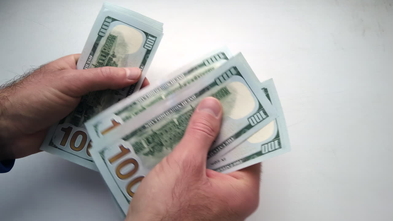 Hands are shown counting multiple hundred-dollar bills, focusing on organizing cash for better financial management. The setting is simple and emphasizes the importance of handling money wisely