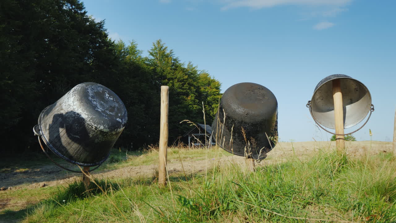 치즈를 만들기 위한 몇 개의 철제 통이 산속의 작은 치즈 공장 울타리에 말려 있다