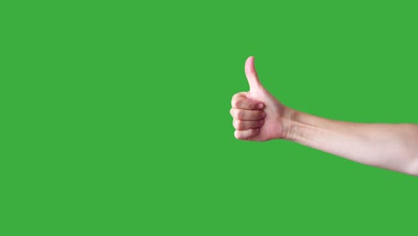 hand giving thumb up and down on green background