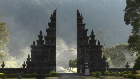 the fog drifts by a traditional balinese temple gate in bali indonesia 4