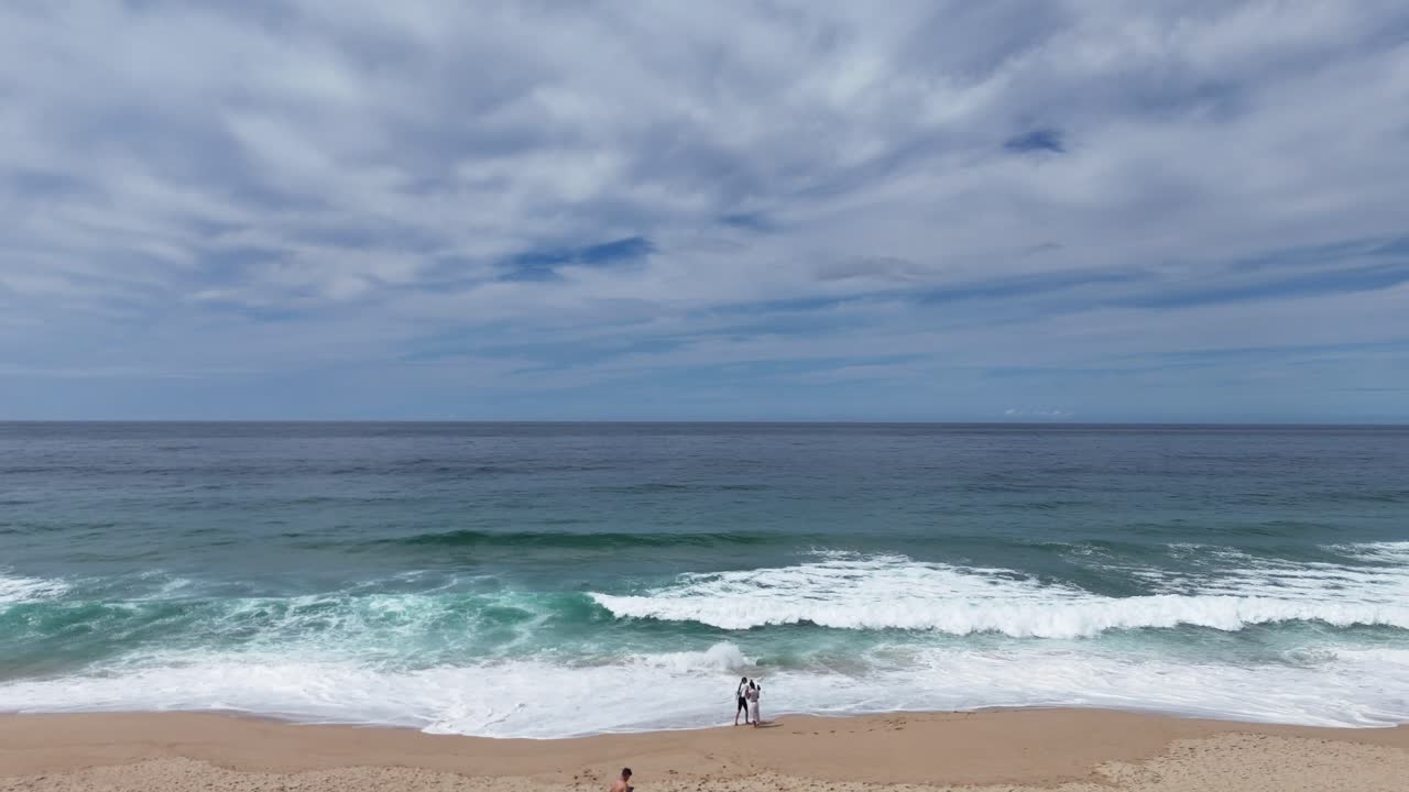 Beach scene with ocean waves and cloudy sky