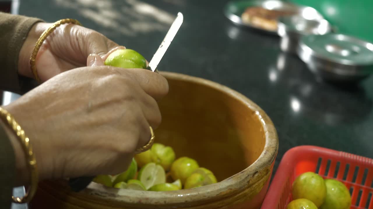 Indian housewife cutting lemons to make traditional lemon pickle, Closeup