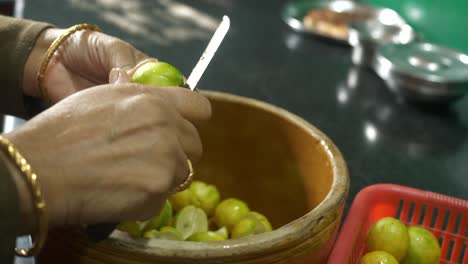 indian housewife cutting lemons to make traditional lemon pickle, closeup