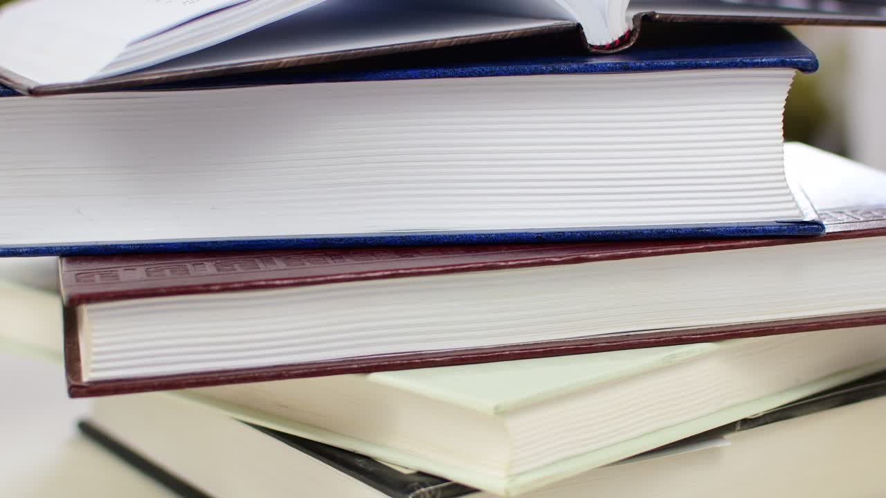 Desk with stack of study books. Textbooks for the student, university. Study from home. Distance education concept.