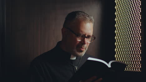 catholic priest reading bible to penitent during confession