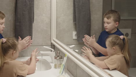 children washing hands in bathroom