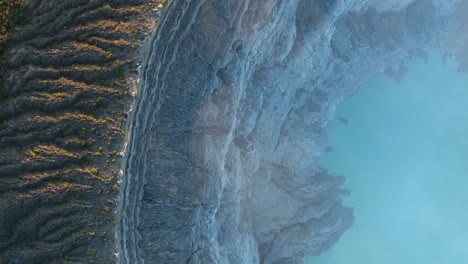 drone de arriba hacia abajo volando a través del cráter ijen en indonesia durante el amanecer