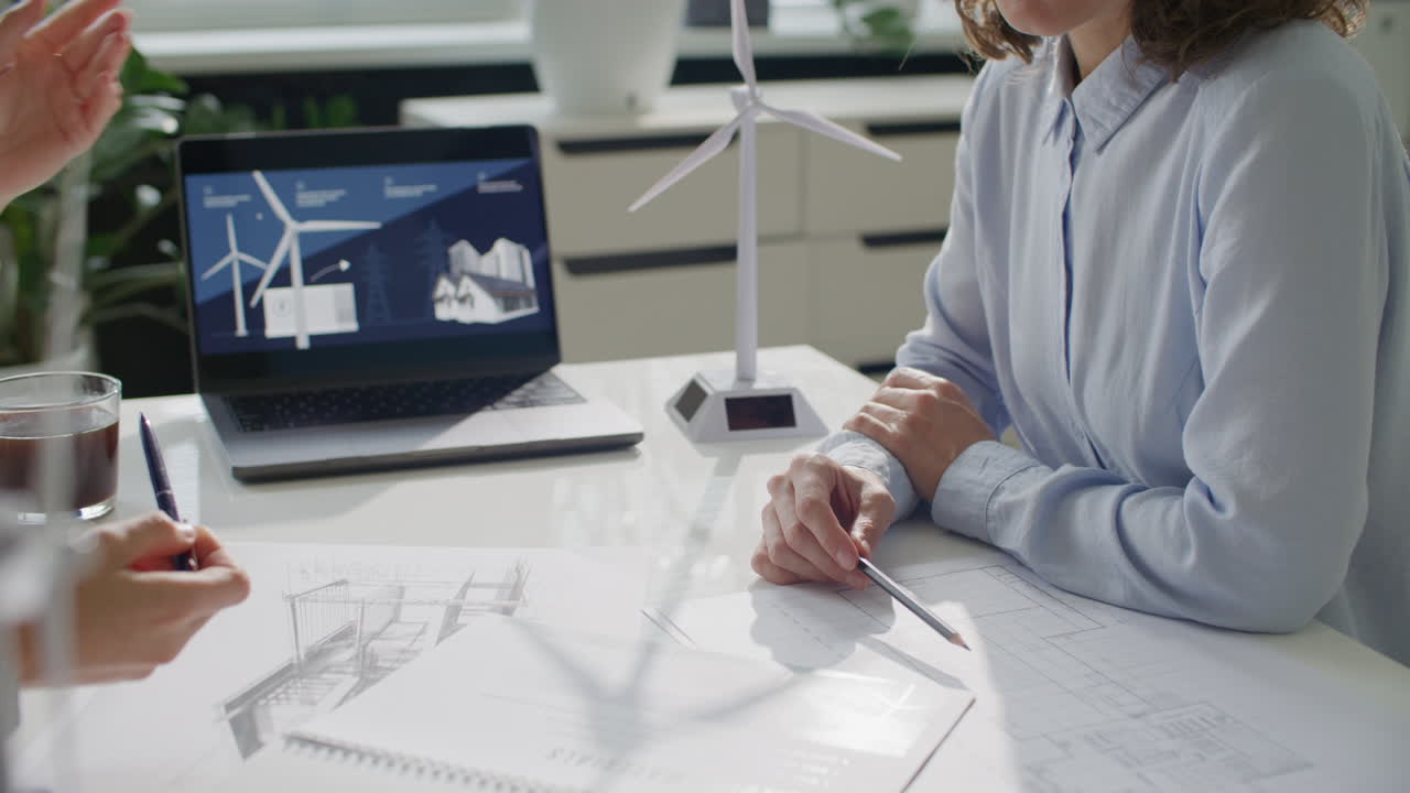 Two Female Engineers Discussing Sustainable Energy Project at Office Meeting
