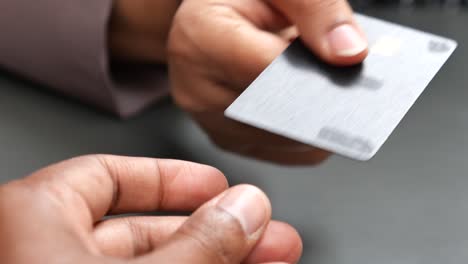 la mano de una persona sosteniendo una tarjeta de crédito negra con un chip.