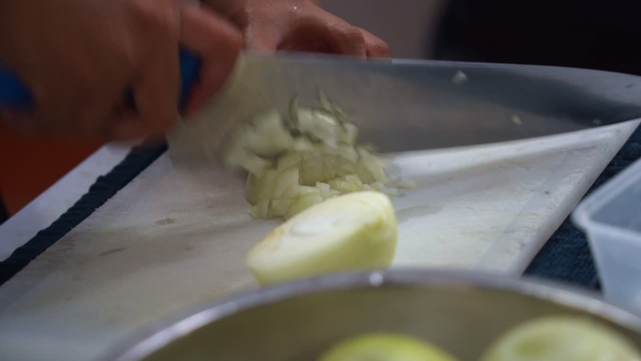 Professional kitchen hand preparing the ingredients for restaurant operation, brunoise cut the onion, close up shot