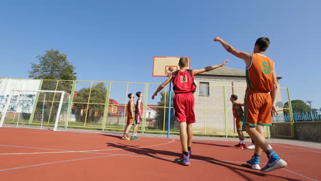 basketball players playing outdoor. bar, ukraine - august 2017: basketball players warming up on the court outdoors