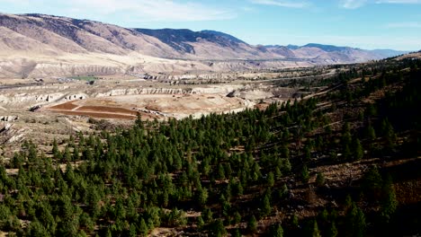 bancos de arena y montañas en kamloops con bosque de agujas perennes en primer plano en un día soleado en verano