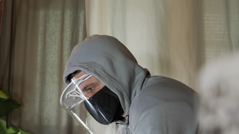 Depressed-Man-wears-Covid-19-protection-at-home,-face-shield-and-mask