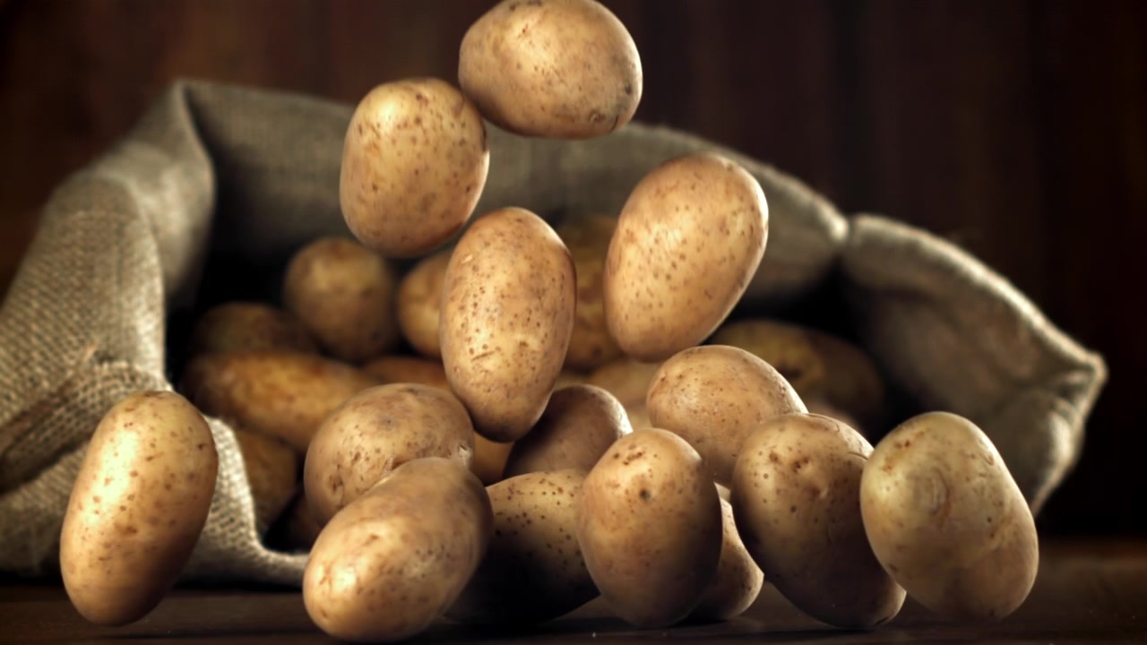 Patate fresche che cadono in un sacco di iuta al rallentatore