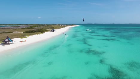 Two-men-kitesurf-paradise-island,-Aerial-shot-beach-camp-Crasqui-Los-Roques